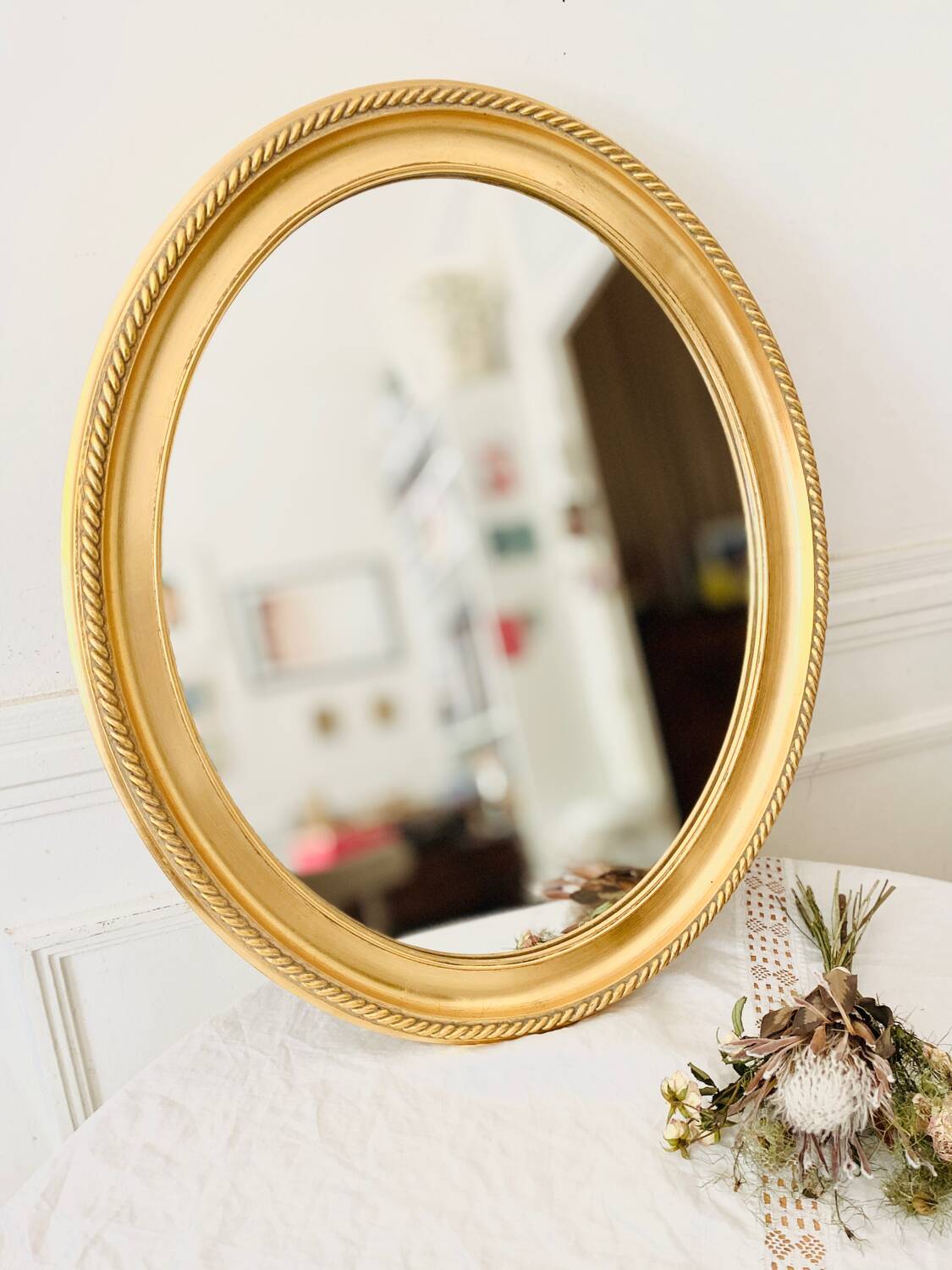Oval wall mirror in gilded wood