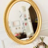 Oval wall mirror in gilded wood