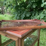 Glass-enclosed old tea table with wooden tray, bronze and brass