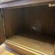 Vintage wooden and glass display cabinet, 15 shelves, gold background.