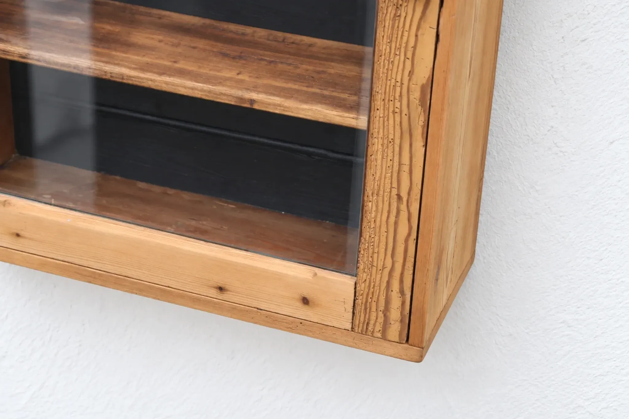 Antique wall display cabinet in natural wood and black – small glass-fronted collector's piece.