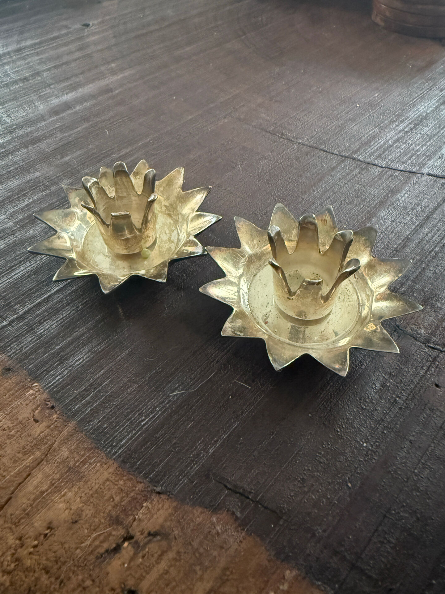 Pair of brass candle holders in the shape of a lotus flower.