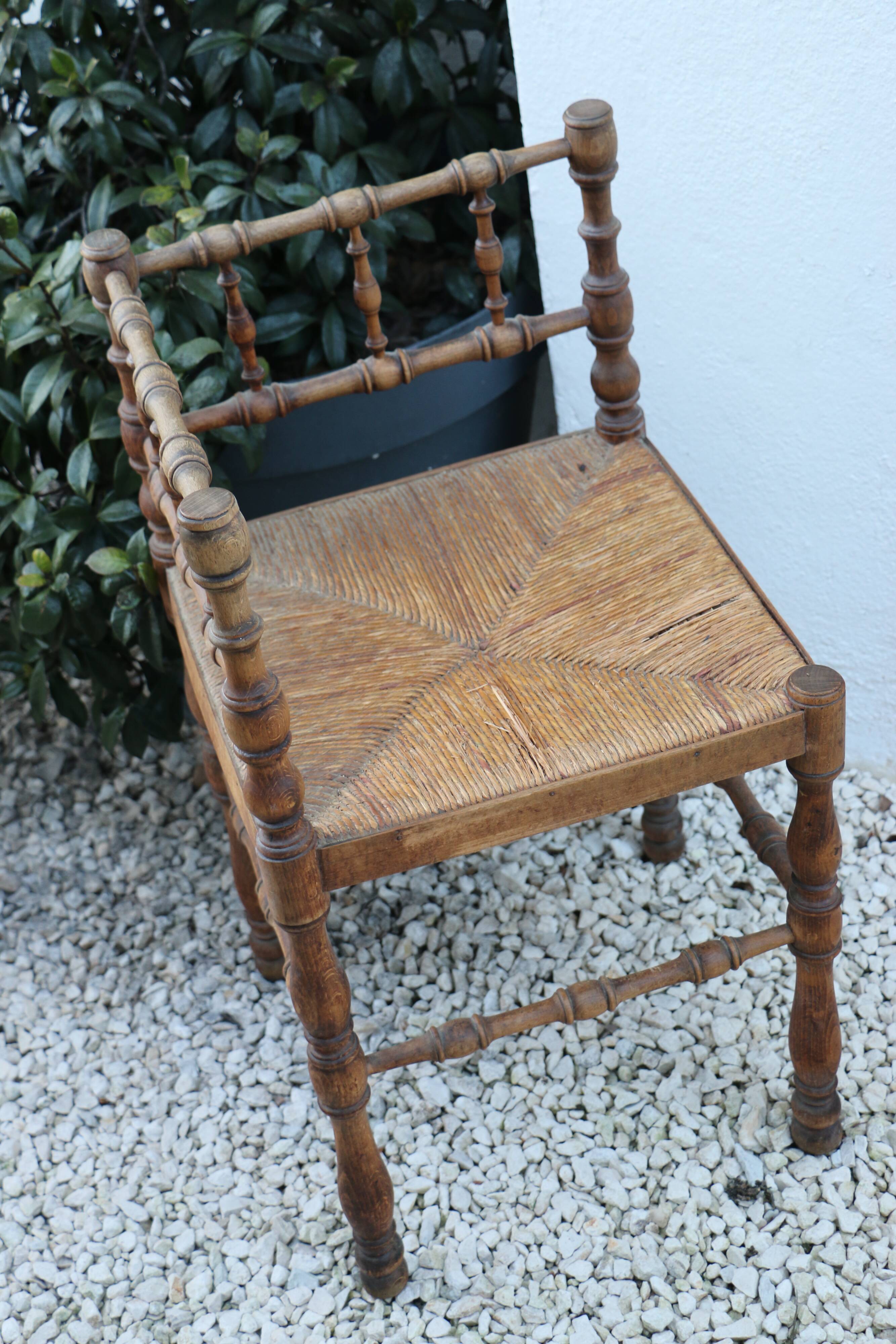 Antique corner chair in wood bamboo style seated in straw