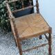 Antique corner chair in wood bamboo style seated in straw