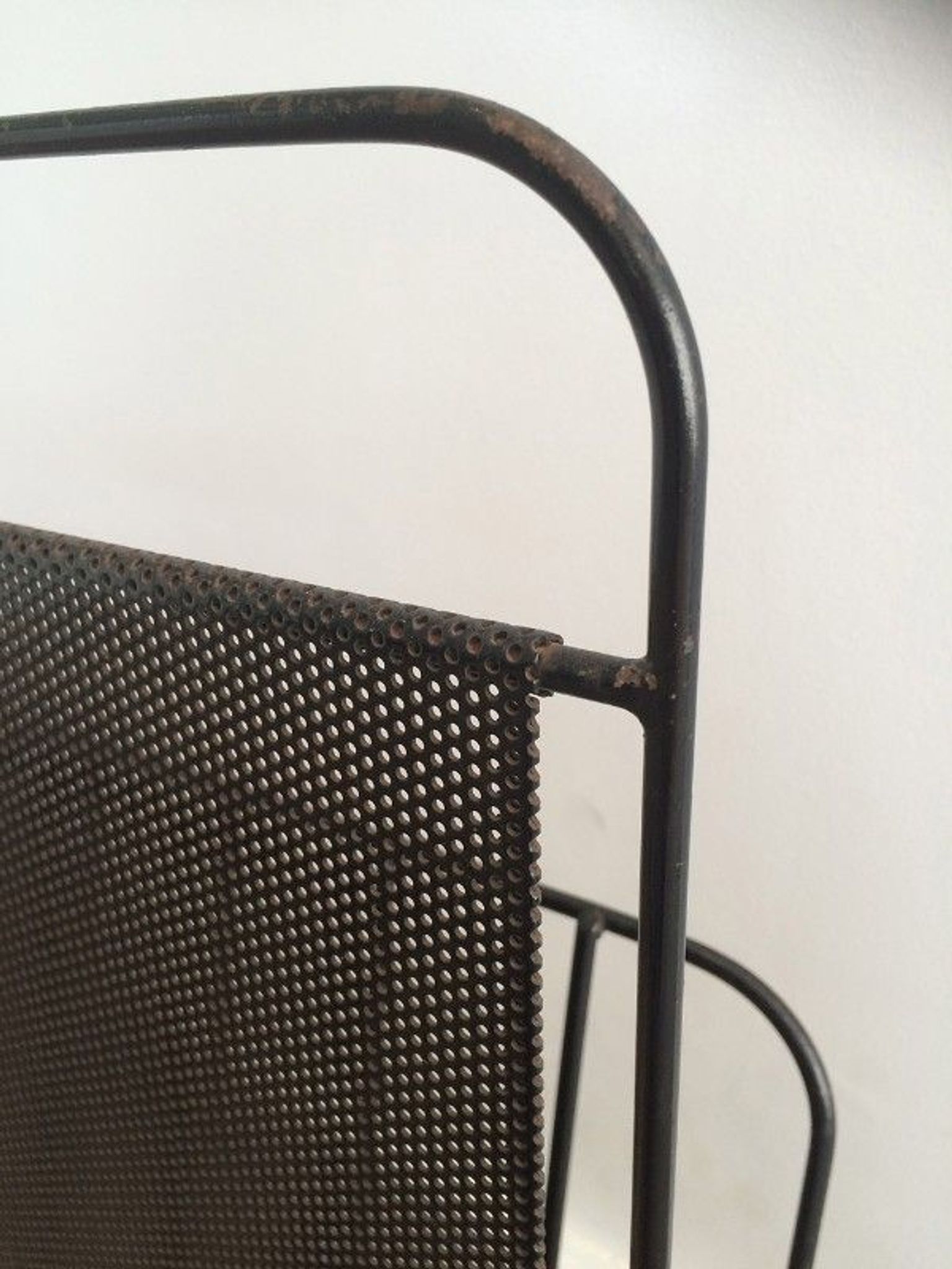 Black lacquered metal and perforated metal magazine rack designed by Mathieu Matégot 50.