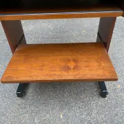 Small Scandinavian-style computer desk on wheels made of wood.