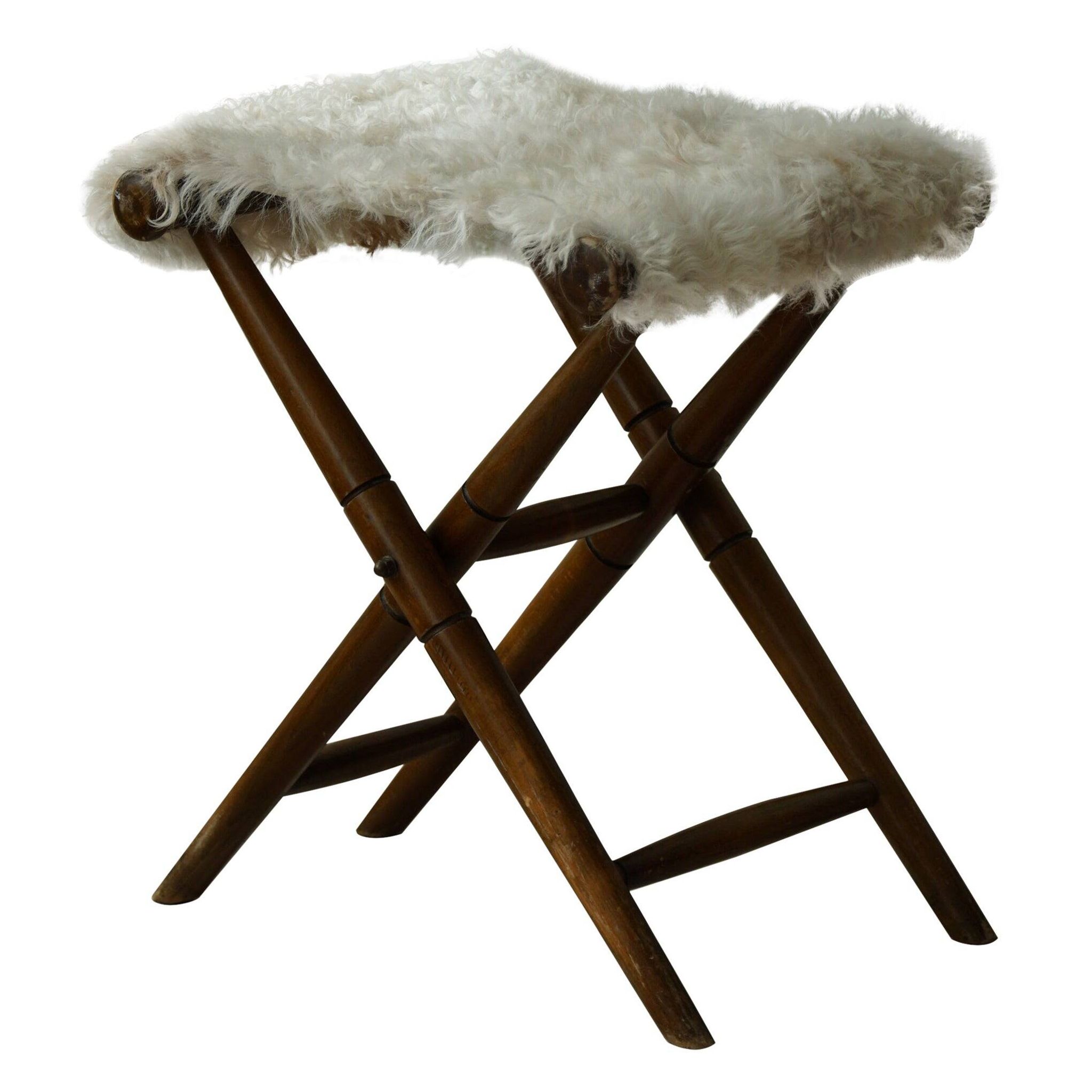 Folding stool, reupholstered in long-haired sheepskin, mid-century modern style, 1950s.