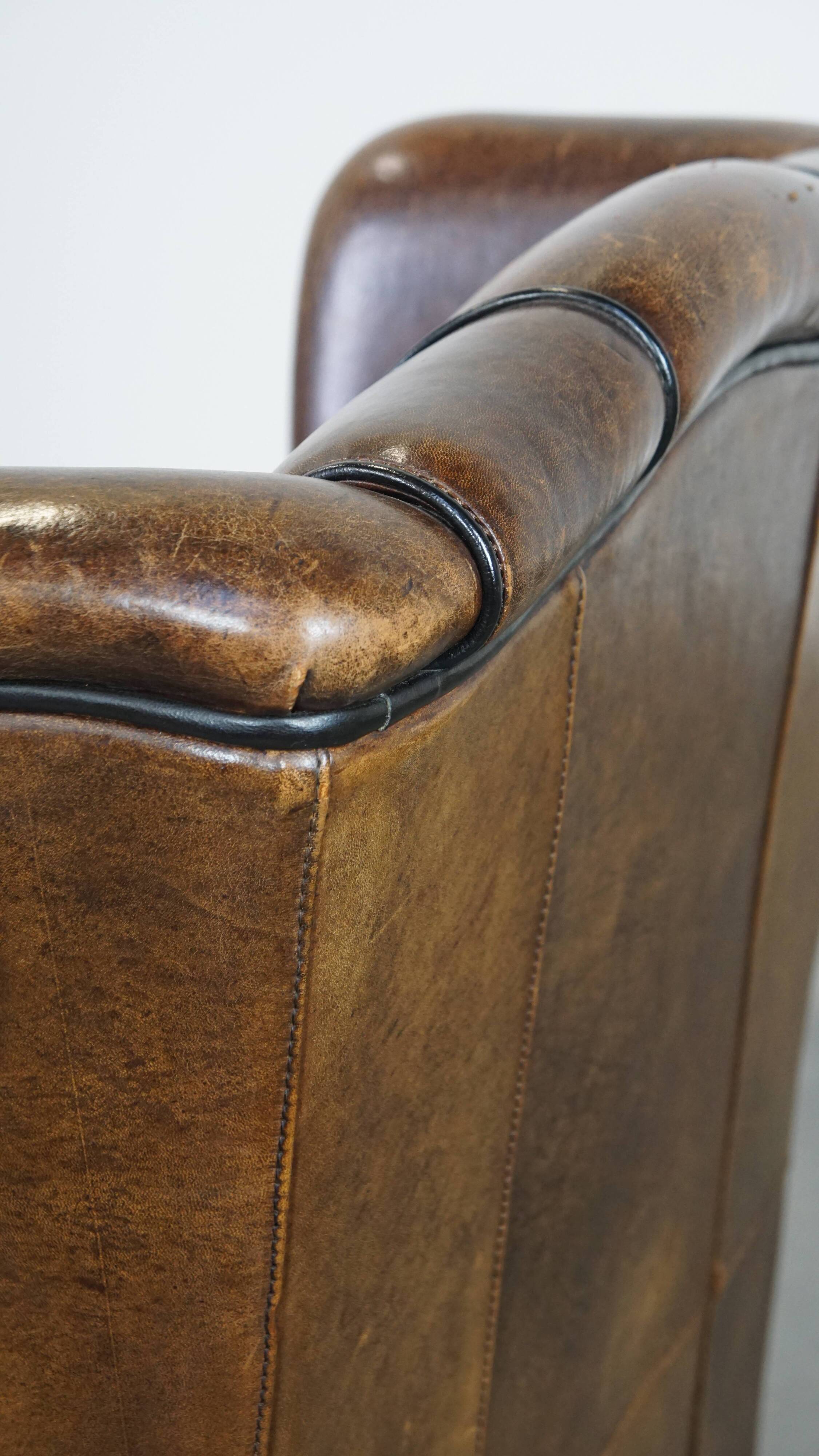 Vintage sheepskin wingback chair finished with black piping