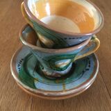 Two cups and their hand-painted ceramic saucer