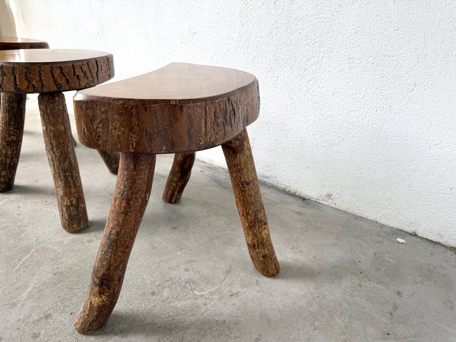 Set of three rustic solid wood tripod stools.