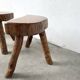 Set of three rustic solid wood tripod stools.