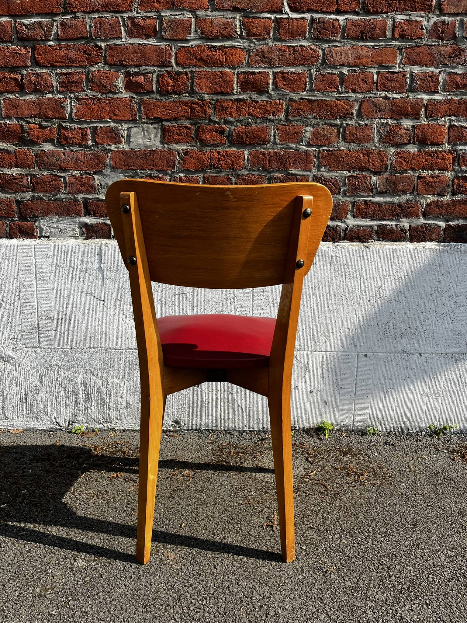 Set of 4 vintage bistro chairs in wood and red faux leather, with splayed legs.