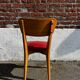 Set of 4 vintage bistro chairs in wood and red faux leather, with splayed legs.