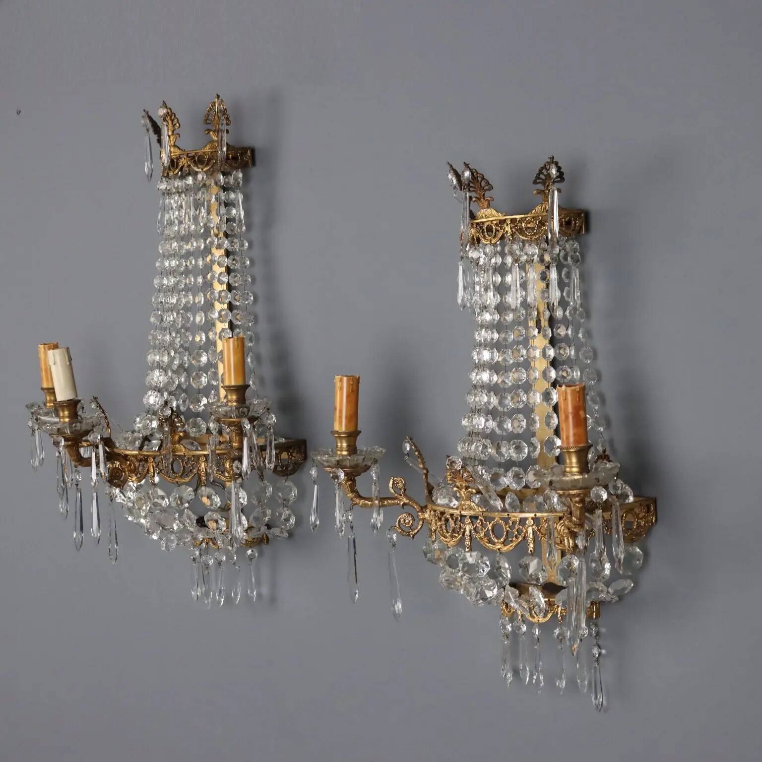 Antique wall sconces in gilded bronze with neoclassical motifs, 20th century.