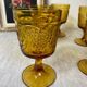 Six amber-colored stemmed glasses
