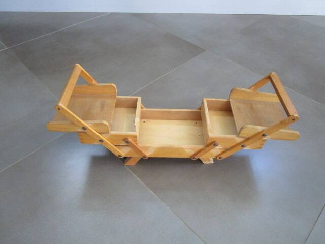 Little worker sewing old wooden table