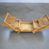 Little worker sewing old wooden table