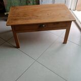 Coffee table with raw wood and a large drawer.