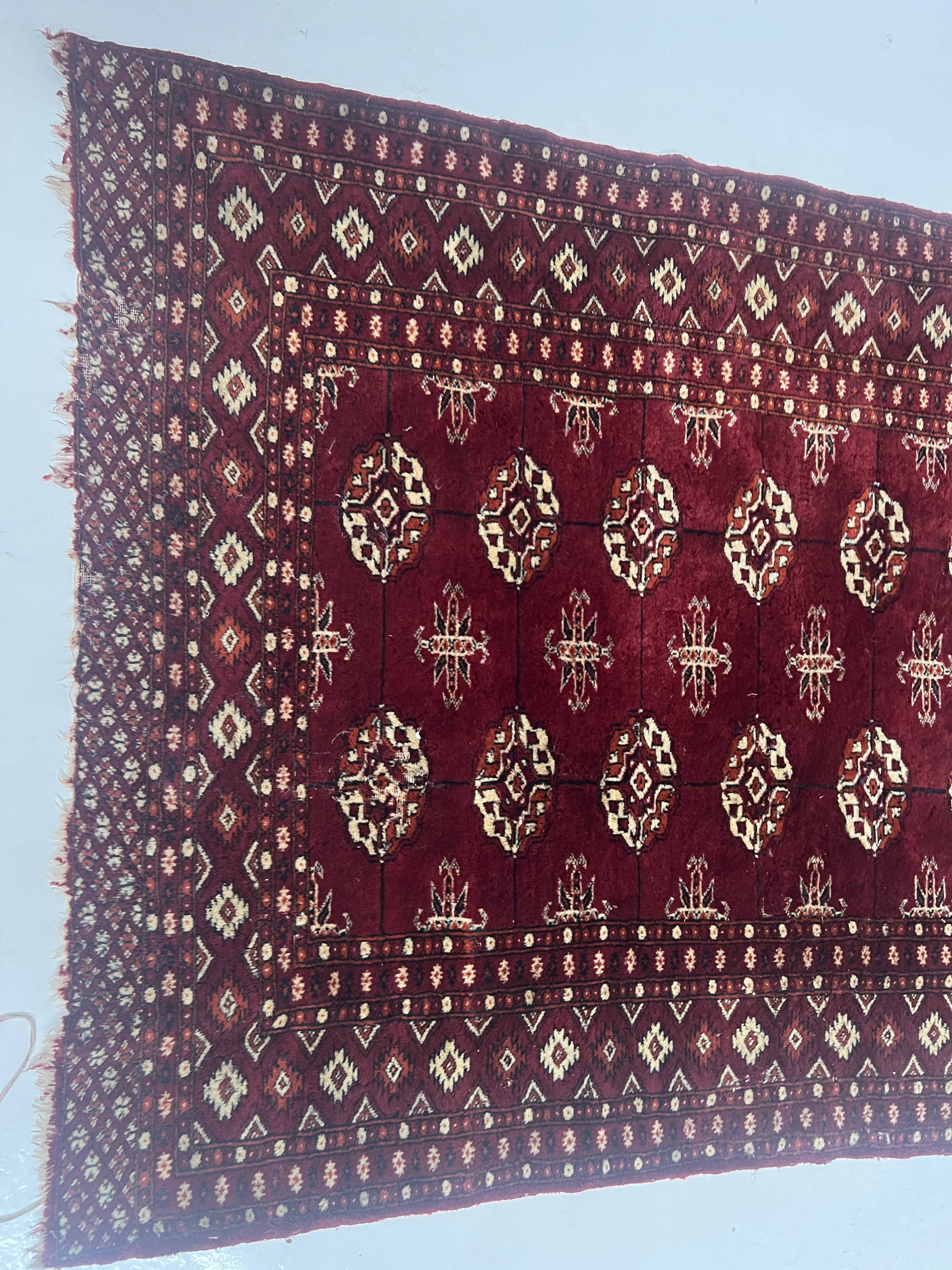 Antique wool rugs with designs on a red background, 20th century.