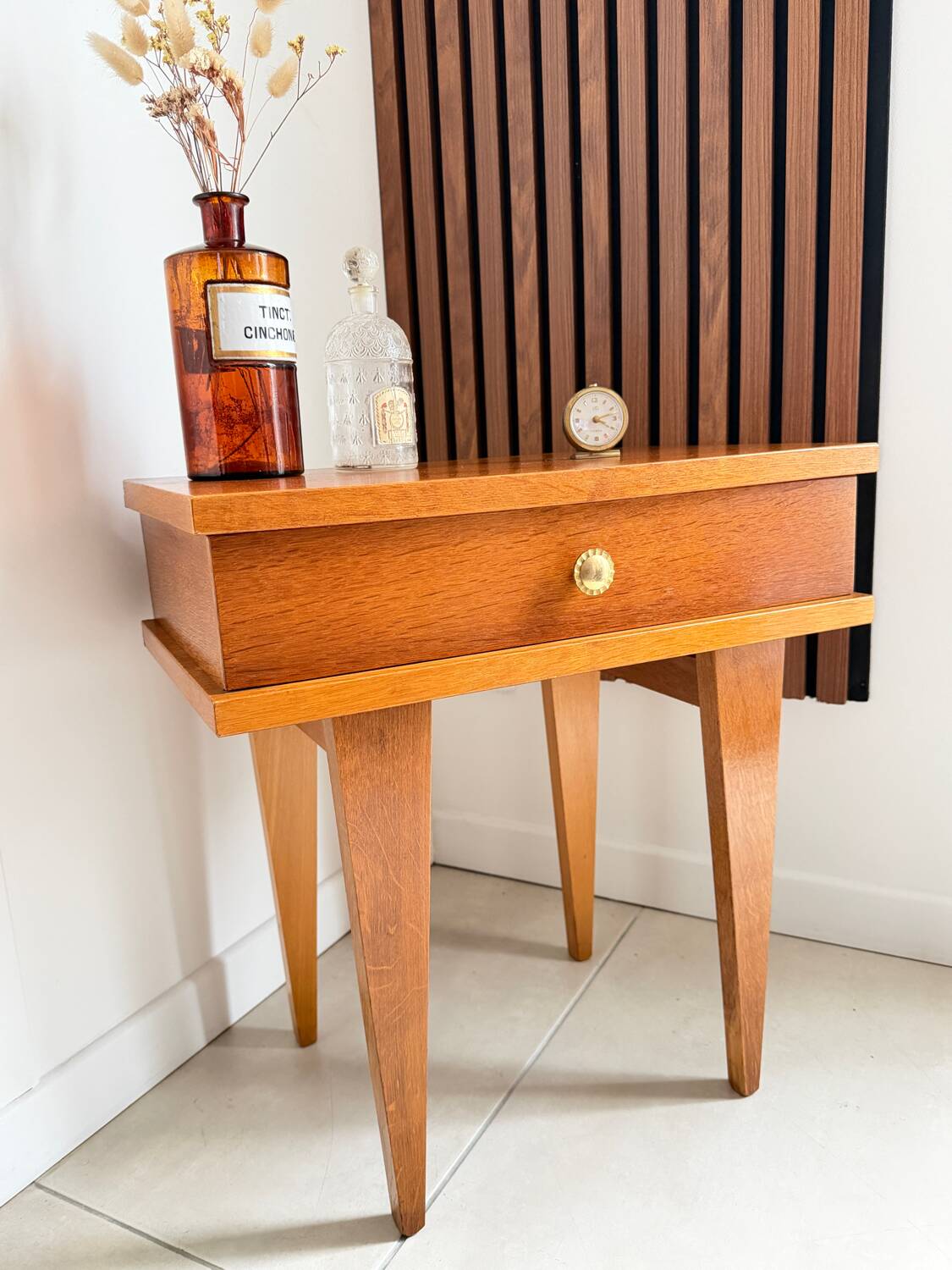 Vintage bedside table with tapered legs.