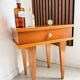 Vintage bedside table with tapered legs.