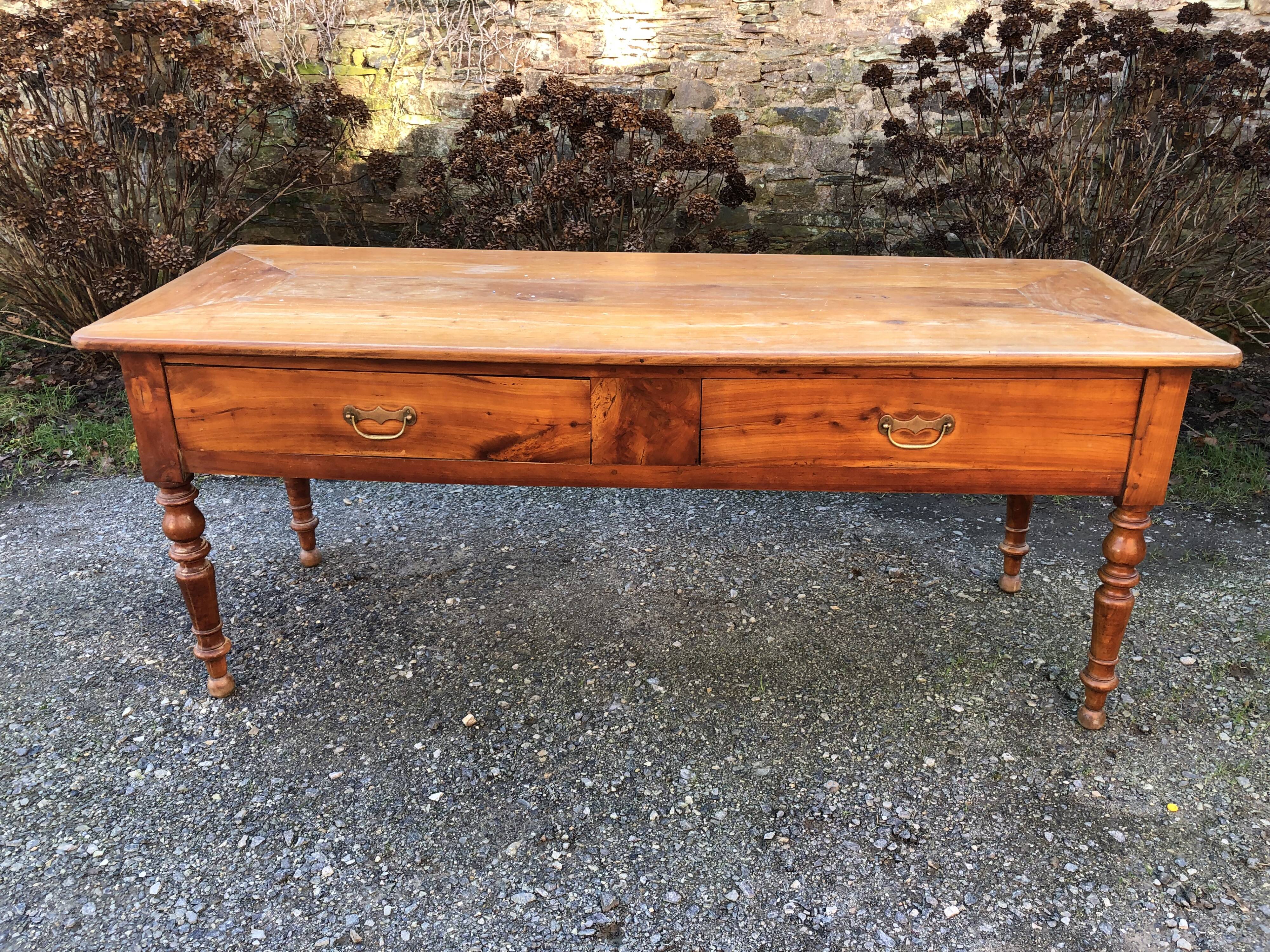 Antique cherry farmhouse table with turned legs and 2 drawers.