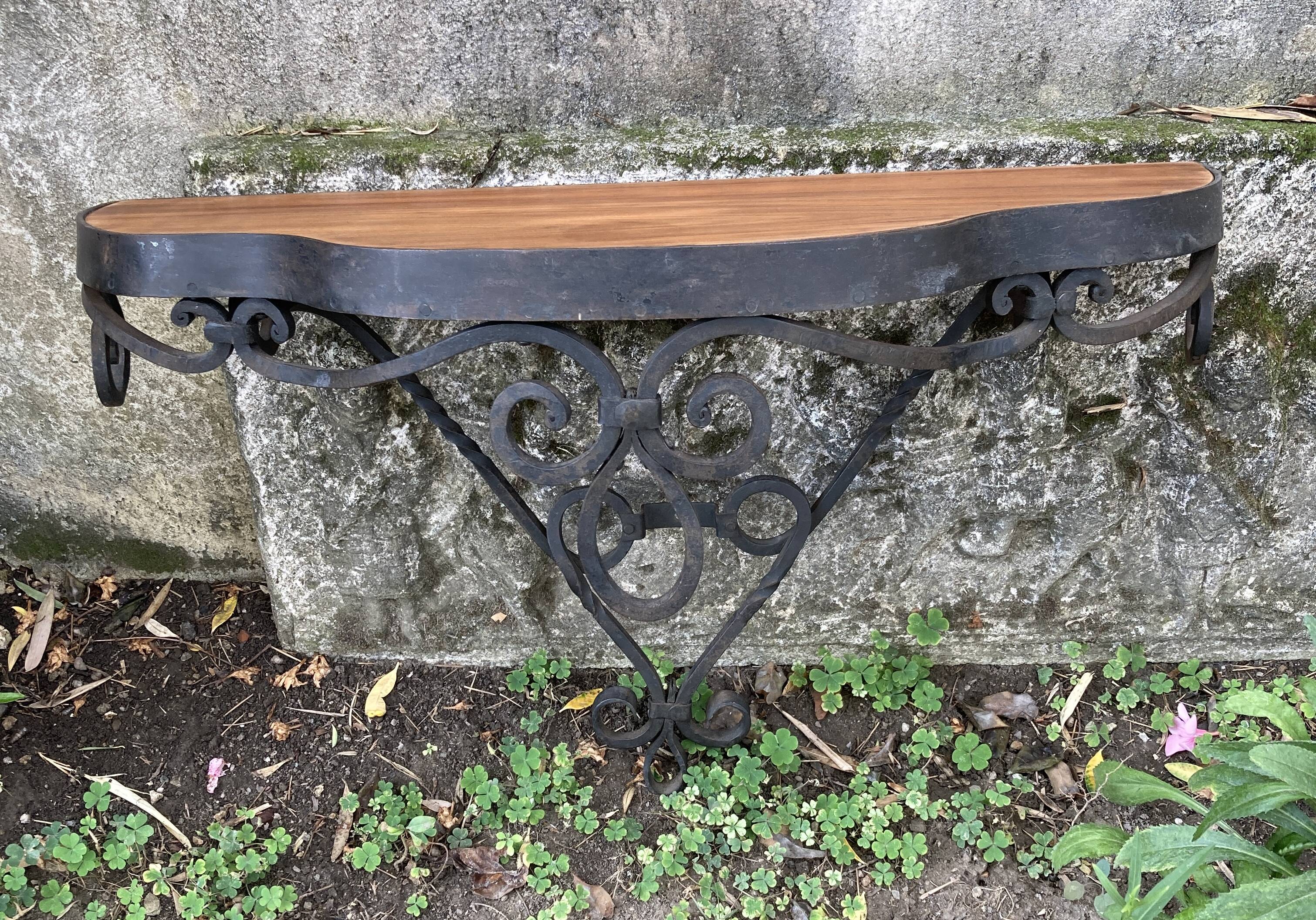 Old wrought iron console with a fleur-de-lis design.