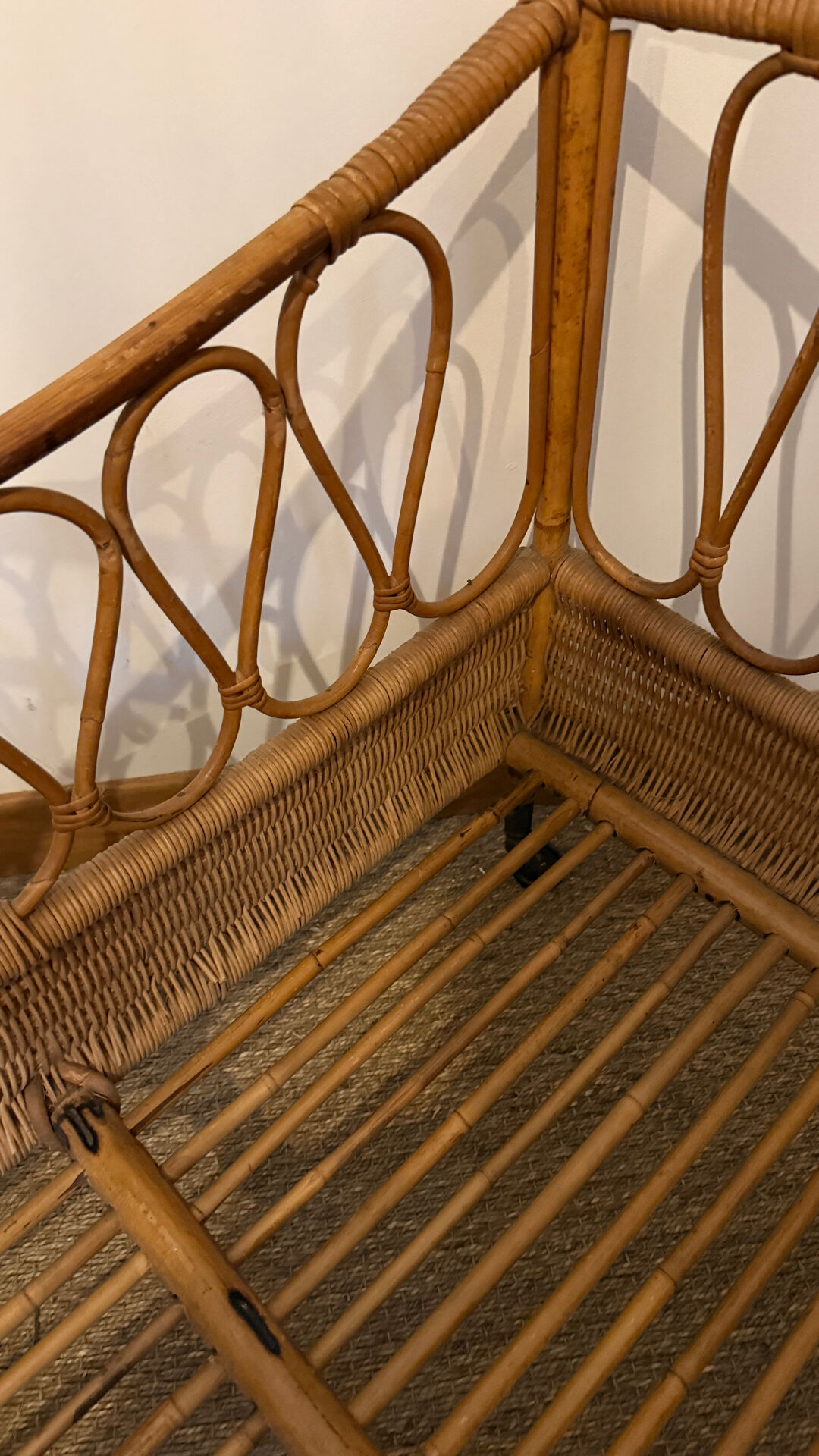 Vintage rattan baby cot on wheels.