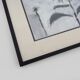 Framed painting with gray flower decor.