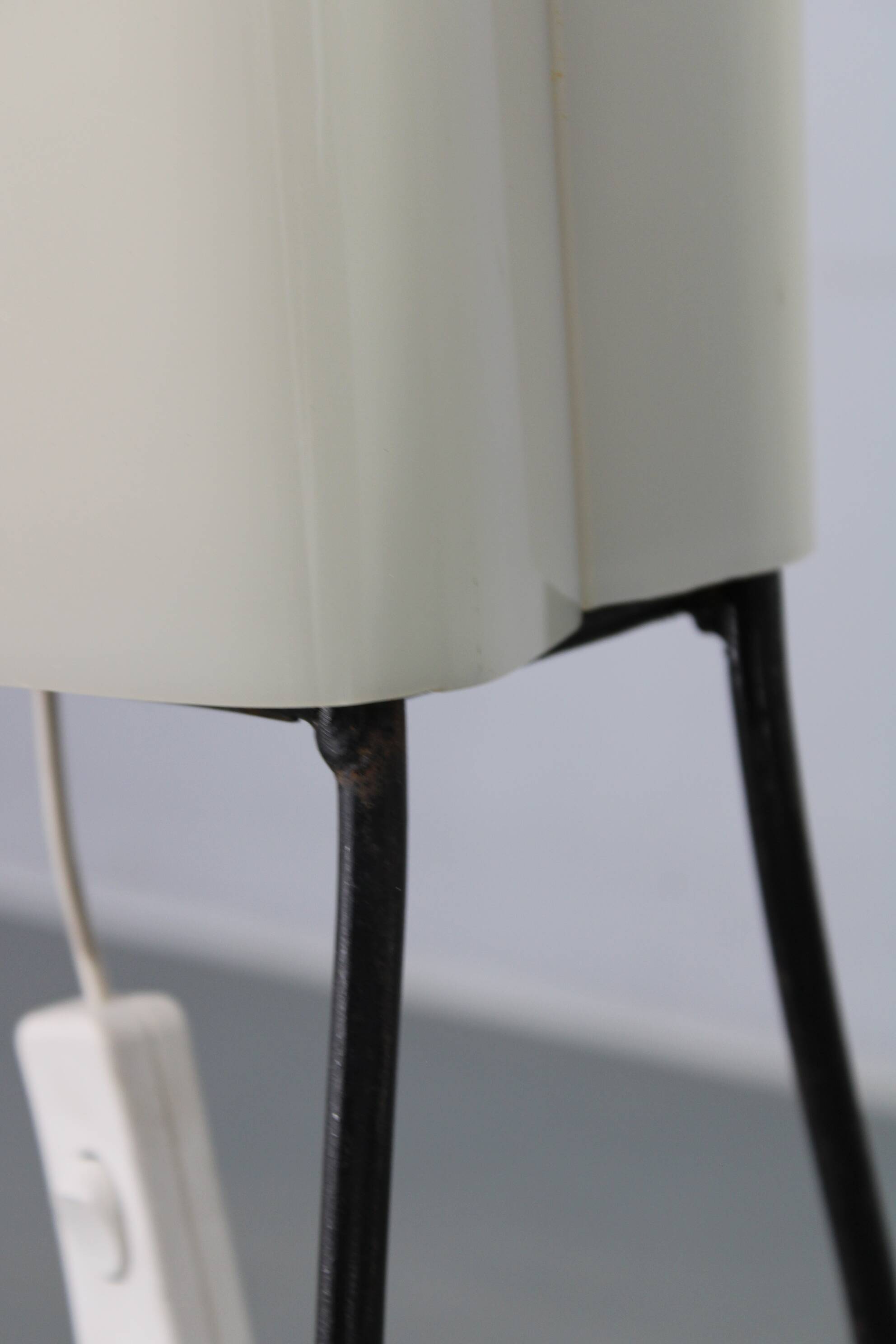 Mid-century modern floor lamp on iron legs with plastic shade and wood accent