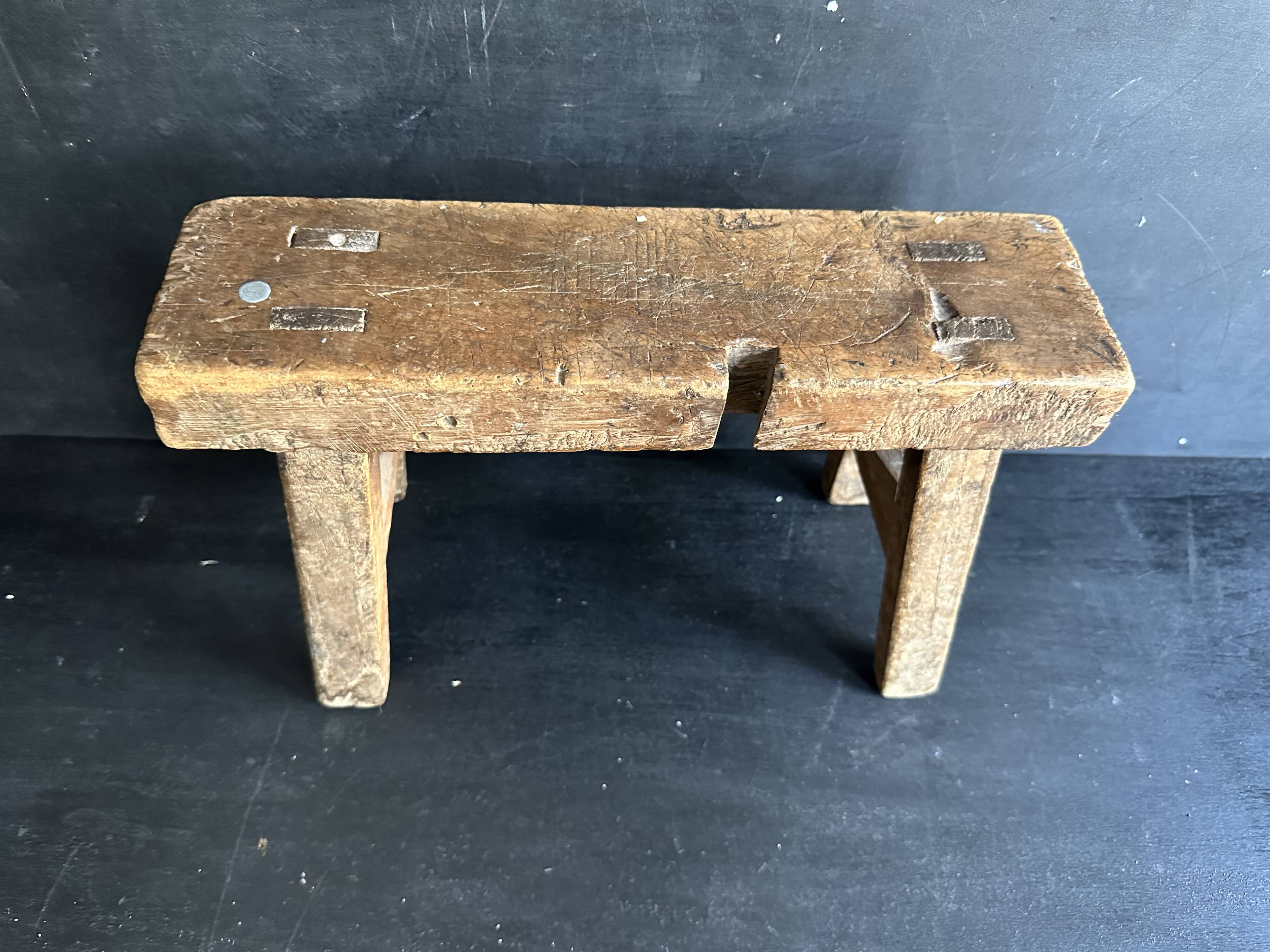 Ancient Chinese farm bench in patinated wood, small rustic stool.