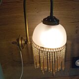 Brass swan neck wall lamp with pink glass globe and Charleston tassels