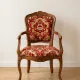 Louis XV style armchair in solid wood with red and gold damask fabric.