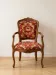 Louis XV style armchair in solid wood with red and gold damask fabric.