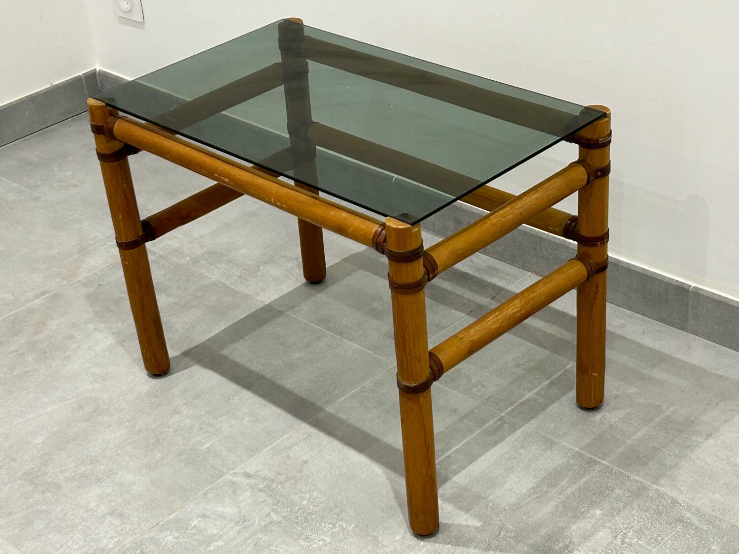 Blonde wood coffee table with smoked glass and leather bindings.
