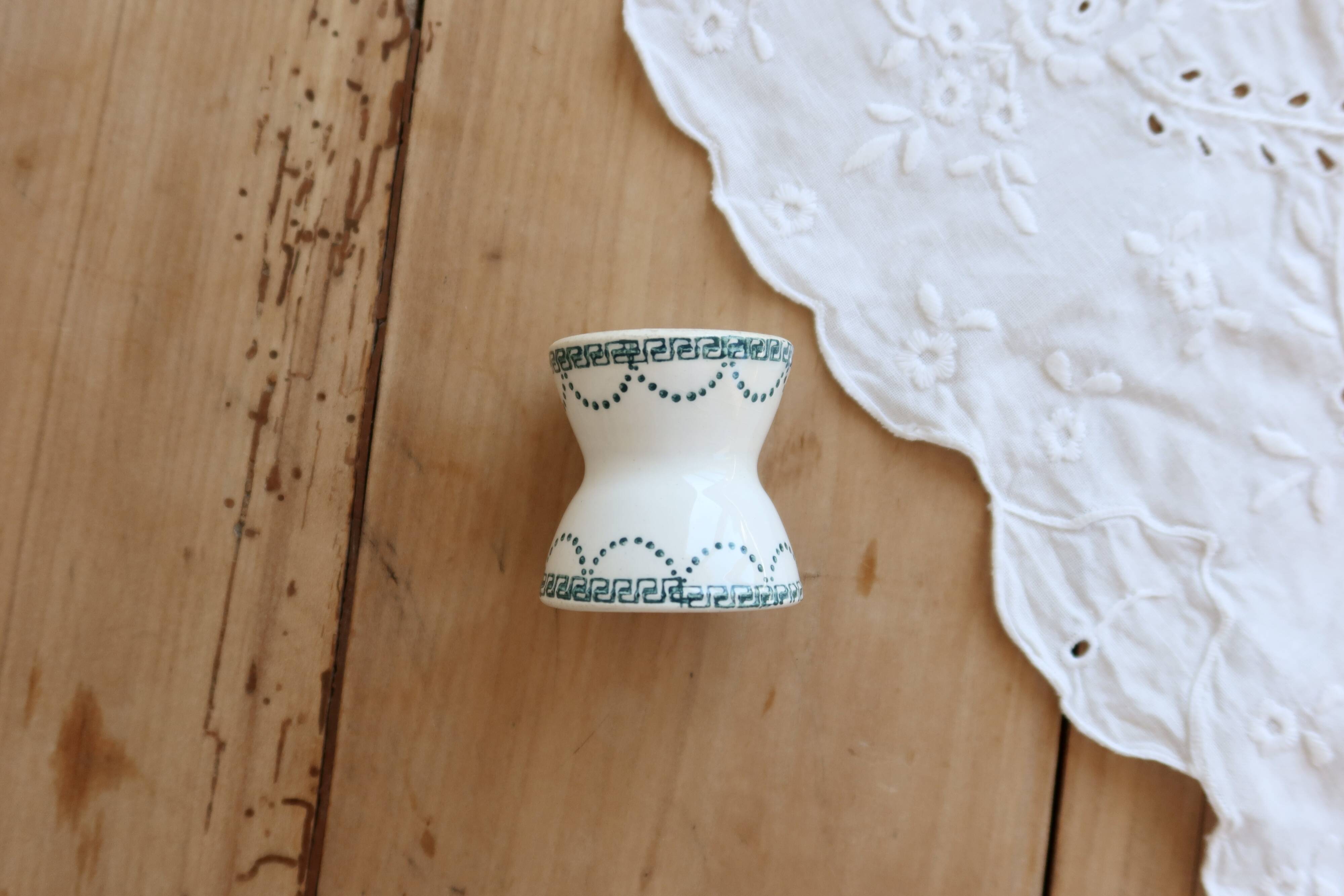 Old diabolo egg cup, ironstone with ivory and green pattern.