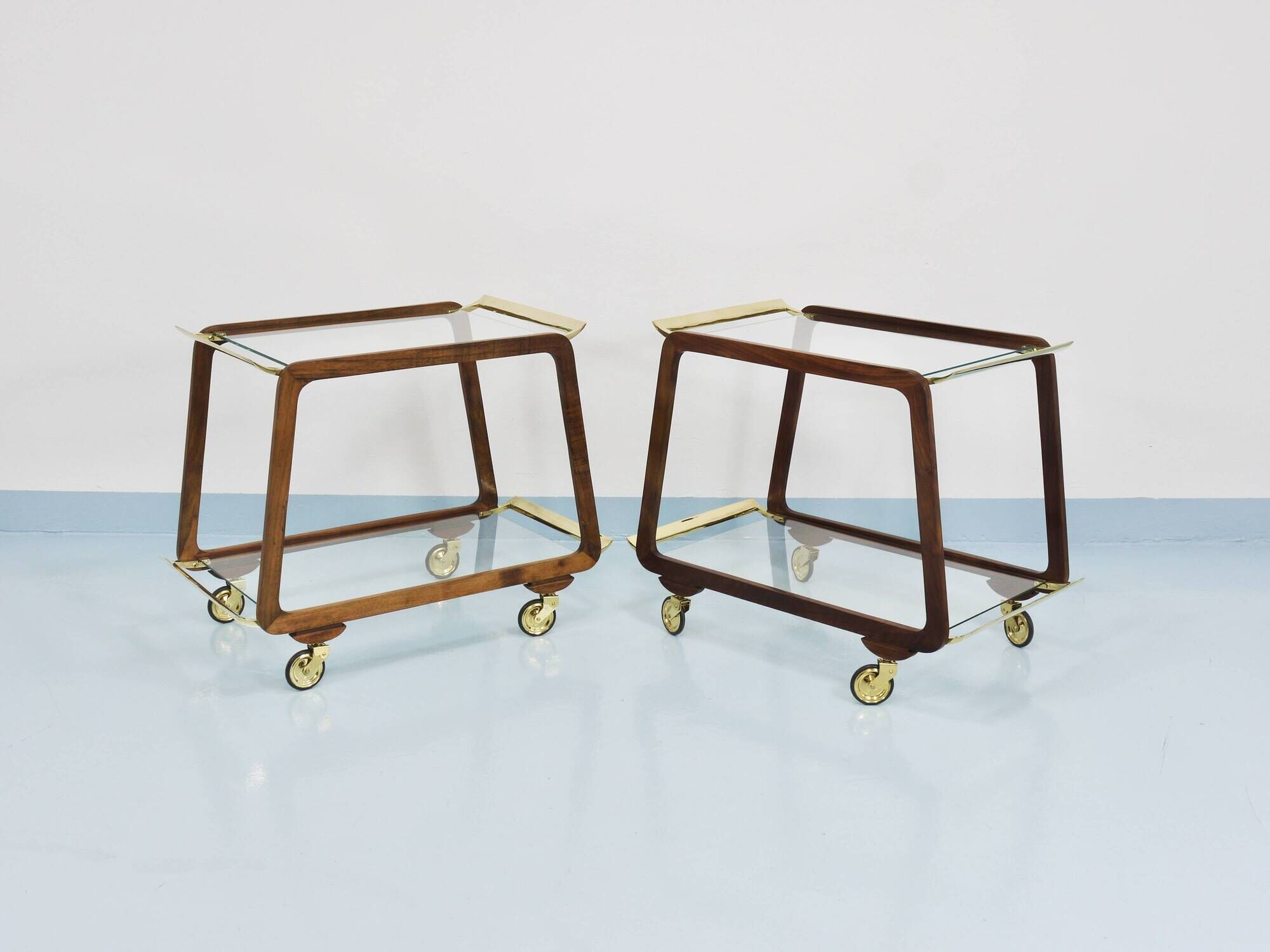 May include: A mid-century modern bar cart with a dark wood frame and two c