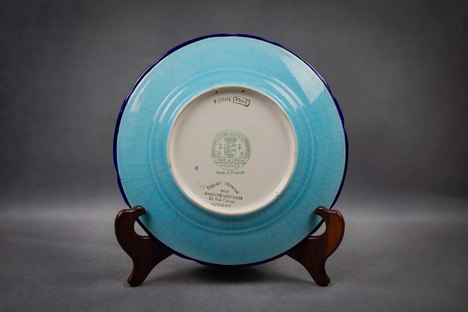 Longwy plate with polychrome enamels, decorated with the "City of Iron" motif.