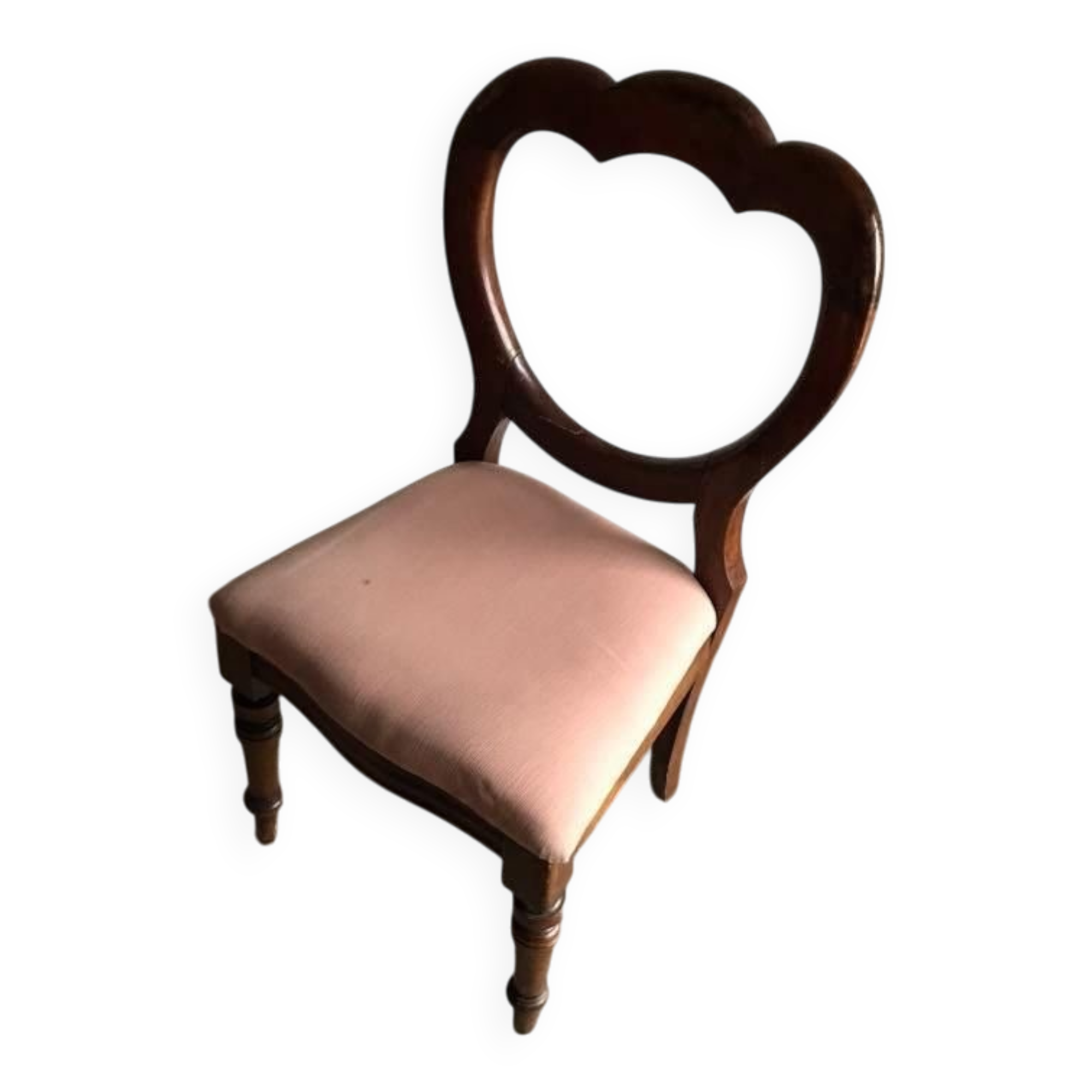 Fauteuil ancien en tissu rose et bois, dossier ajouré en cœur, pieds tournés