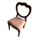 Fauteuil ancien en tissu rose et bois, dossier ajouré en cœur, pieds tournés
