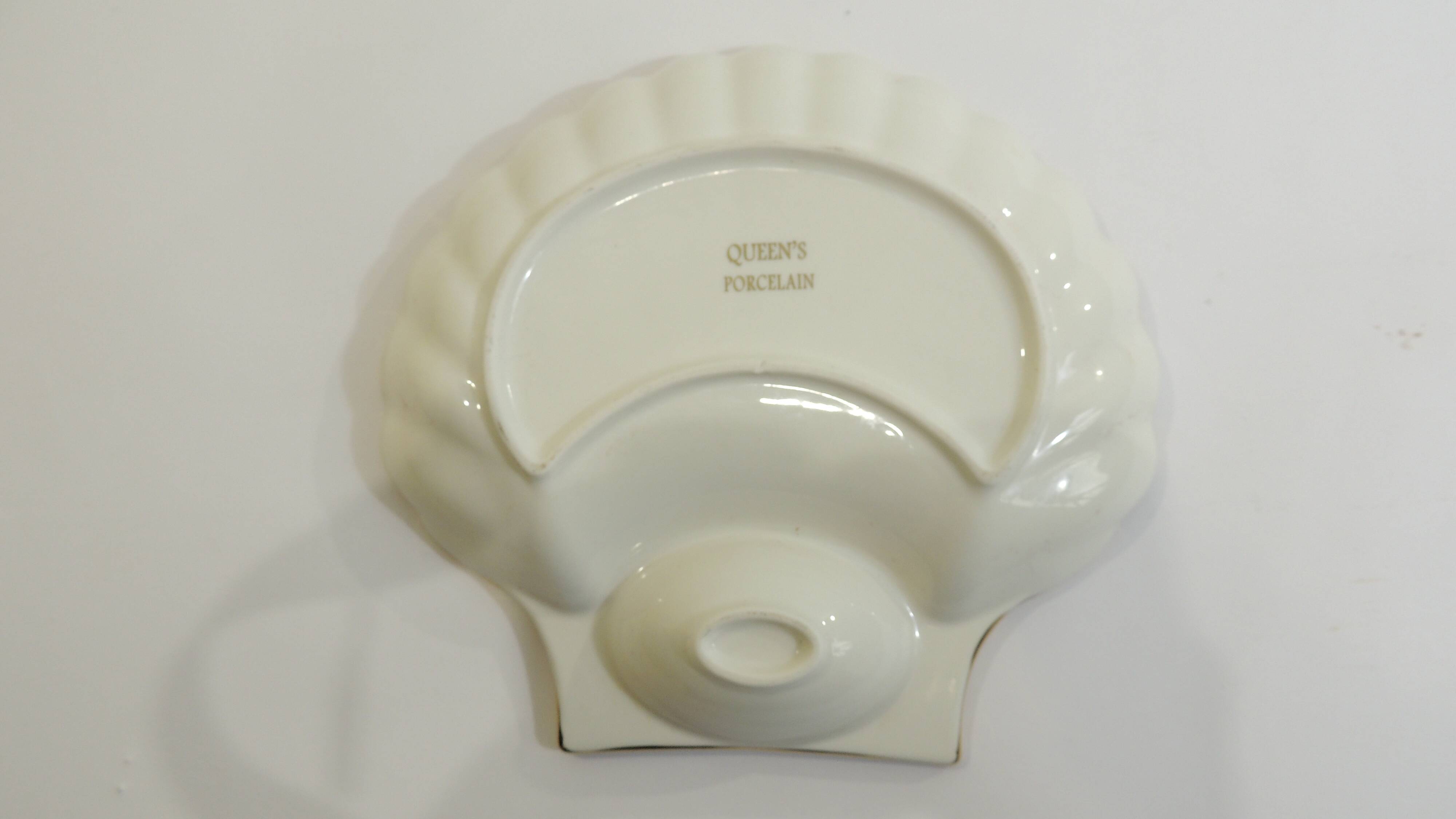 Shell-shaped porcelain pocket bowl from Queen’s Porcelain, with a gold rim.