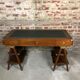 Walnut desk with green leather top resting on two trestles