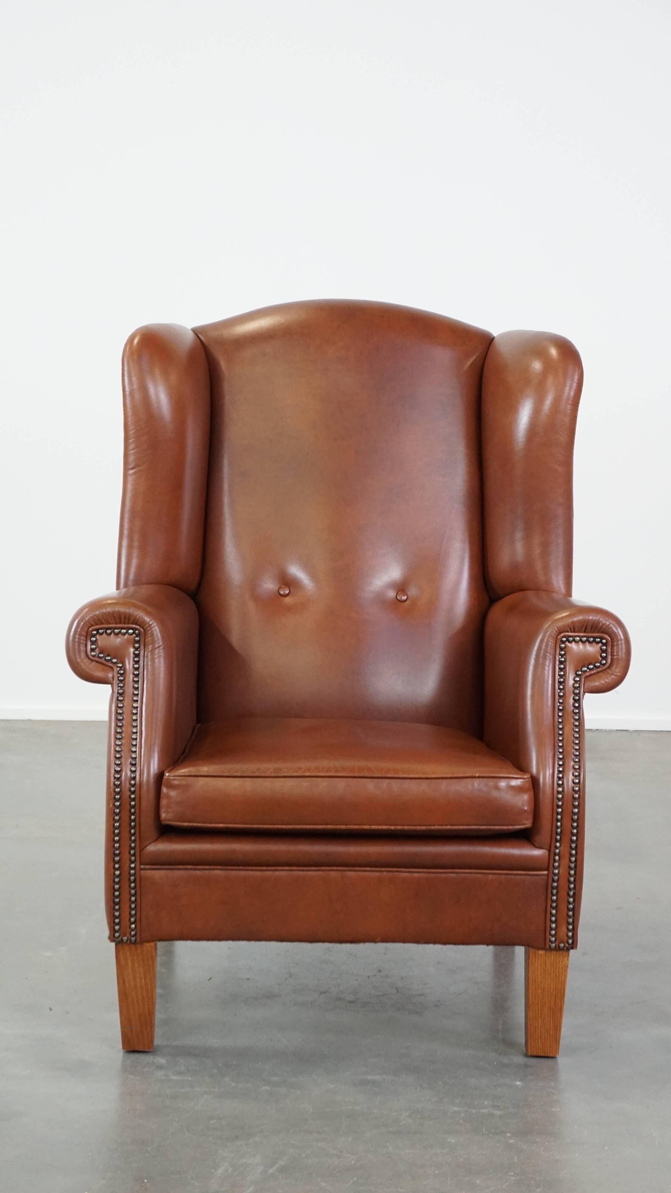 Cognac-colored leather wingback chair in English style