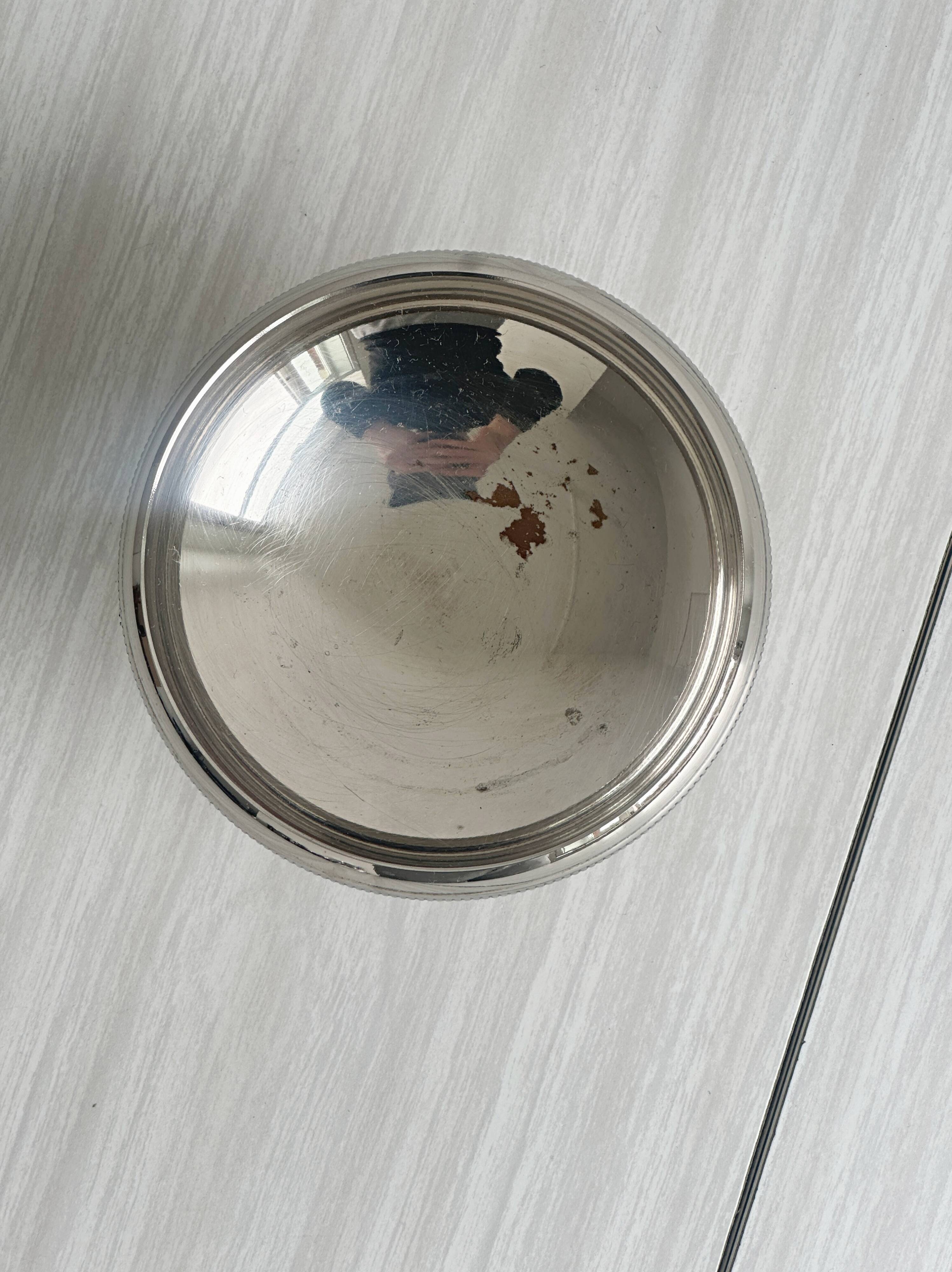 Small silver-plated metal bowl on a stand.