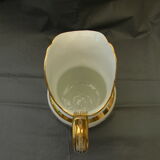 Milk jug or antique pitcher in white and gold porcelain.
