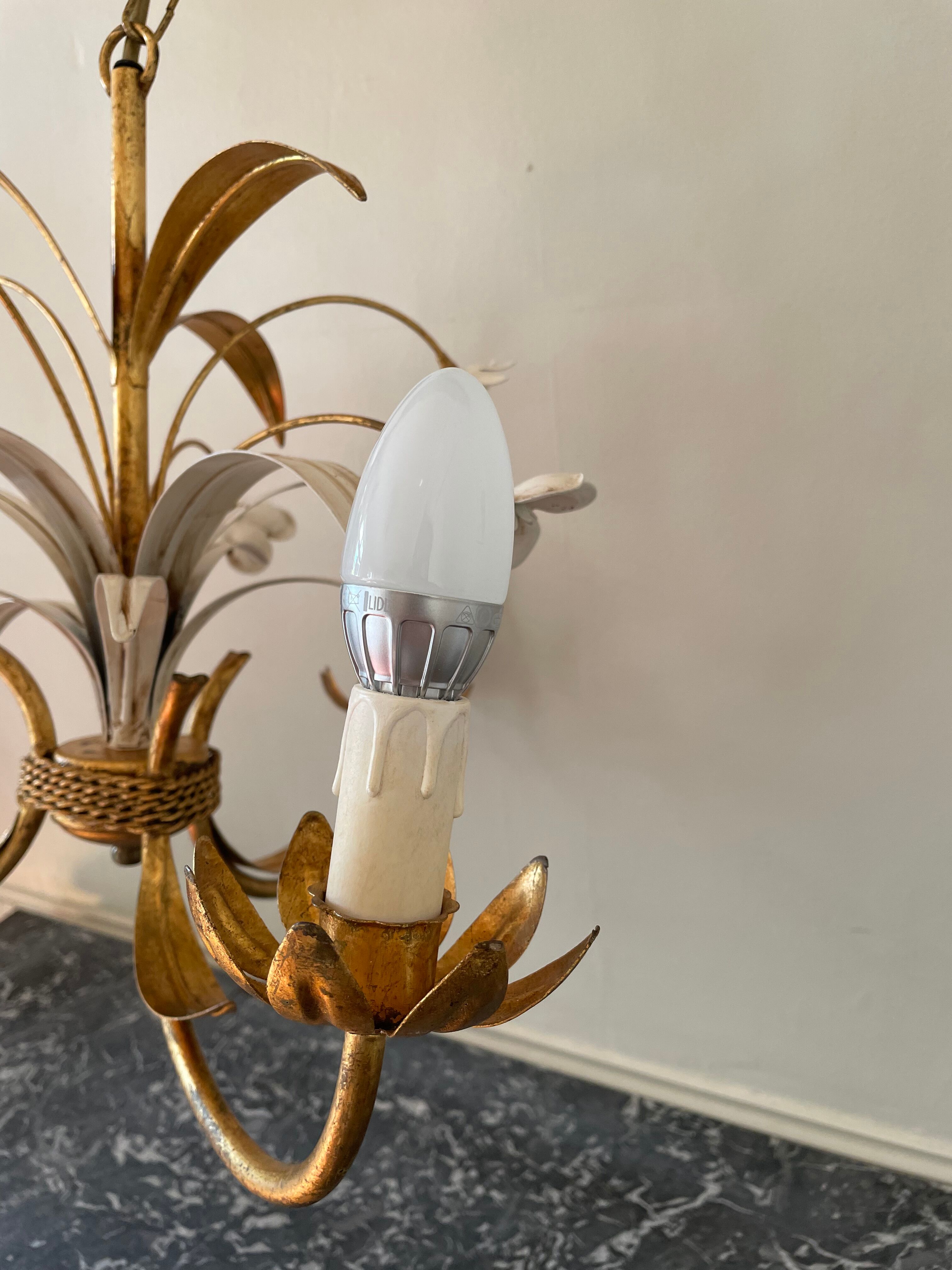 Golden metal chandelier decorated with flowers