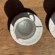 Pair of white porcelain cups from ADP France with a floral pattern and their s
