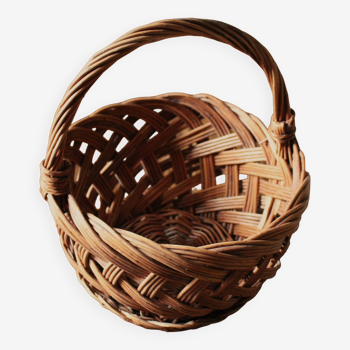 Round woven dark wicker basket with openwork vintage handle