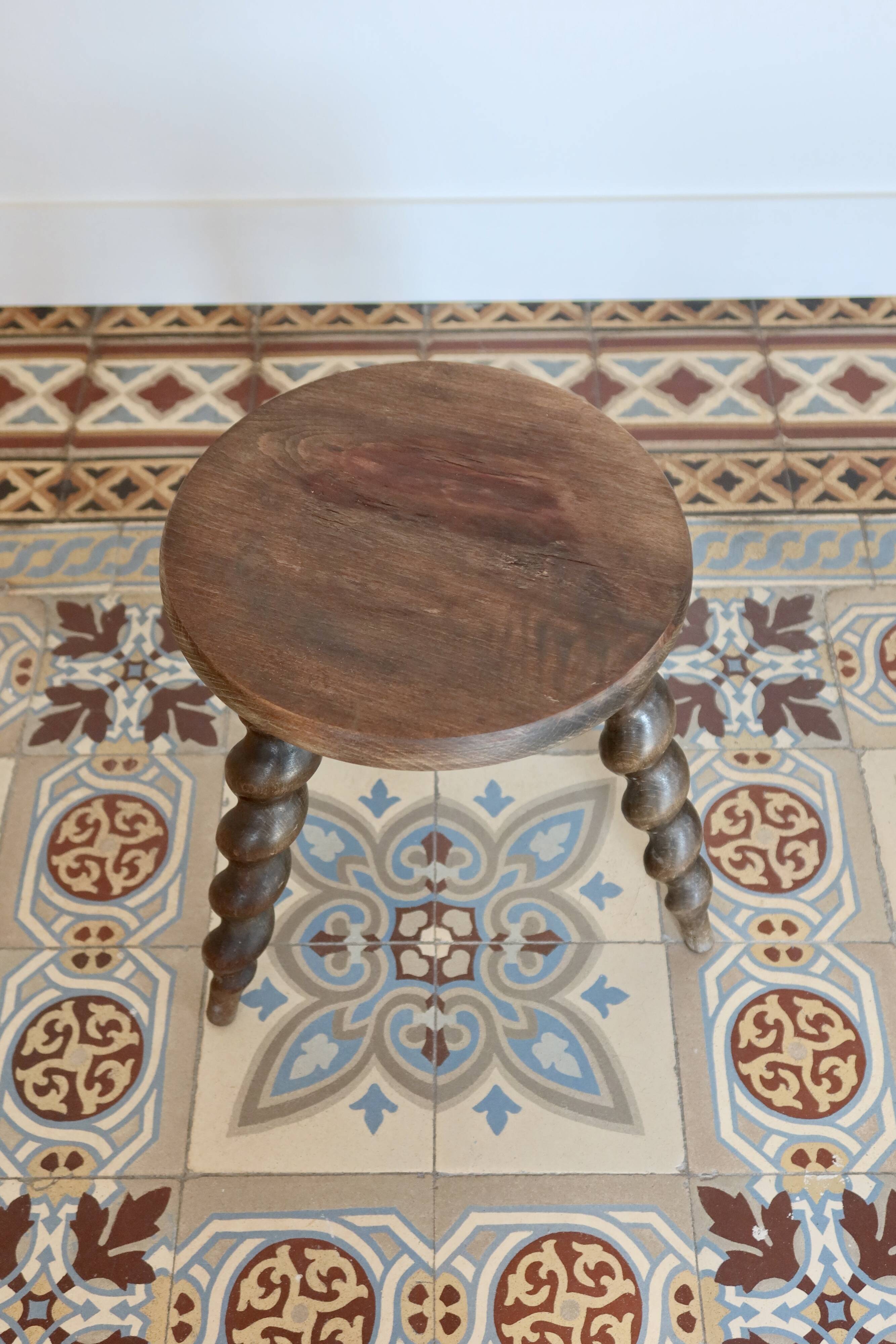 Antique tripod stool made of turned wood.