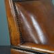 Art deco armchair in sheepskin with black piping and decorative nails